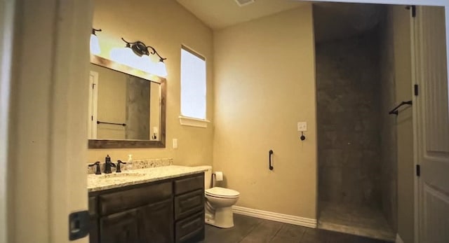 bathroom with walk in shower, vanity, and toilet