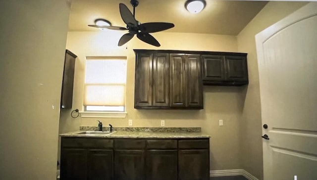 kitchen featuring dark brown cabinetry, sink, and ceiling fan