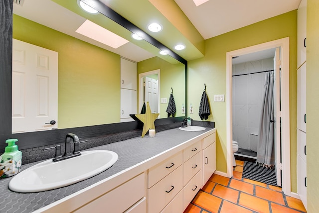 full bath with double vanity, toilet, tile patterned flooring, and a sink