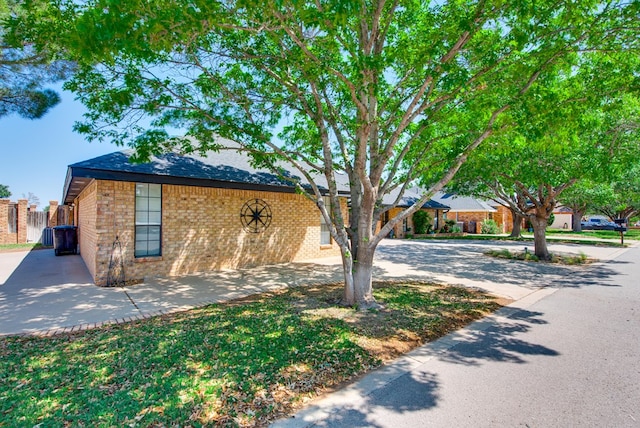 view of front of property featuring brick siding and fence