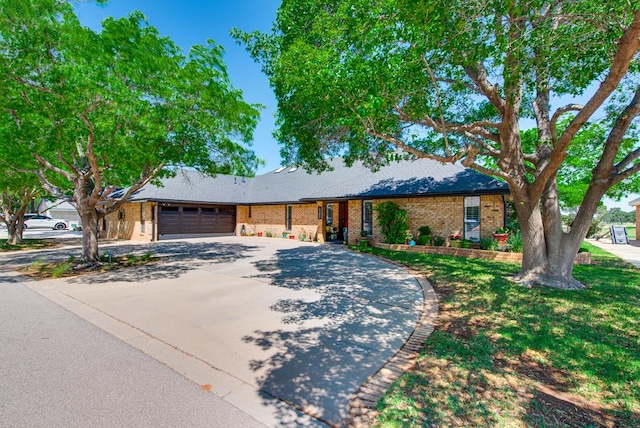 ranch-style house featuring concrete driveway, an attached garage, and brick siding