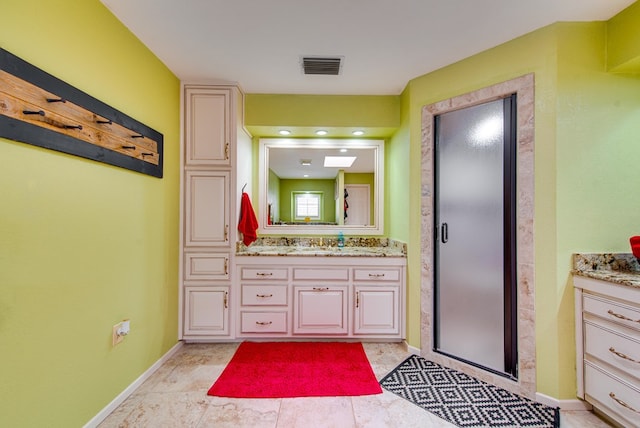 full bathroom with vanity, baseboards, a shower stall, and visible vents