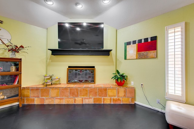 living area featuring concrete floors, plenty of natural light, and vaulted ceiling