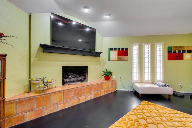 living room featuring baseboards, a fireplace with raised hearth, and recessed lighting