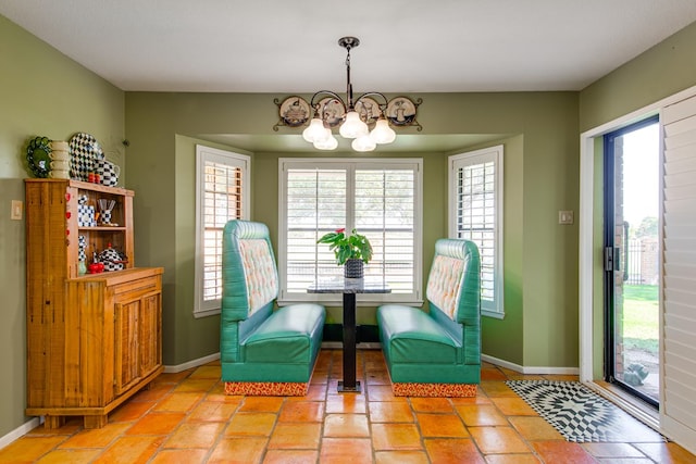 living area featuring baseboards and a notable chandelier