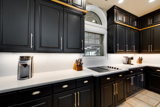 kitchen featuring black electric cooktop, light stone countertops, and light tile patterned floors