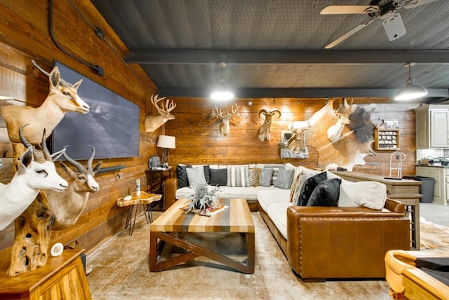 living room with beamed ceiling, ceiling fan, and wooden walls