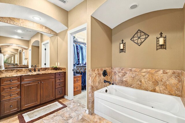 1302 Telluride Dr, Midland, TX 79705 - full bath featuring vanity, a bath, a walk in closet, and marble finish flooring