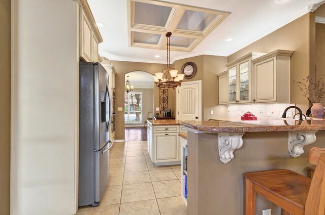 1302 Telluride Dr, Midland, TX 79705 - kitchen featuring stainless steel fridge with ice dispenser, cream cabinets, a peninsula, a chandelier, and ornamental molding