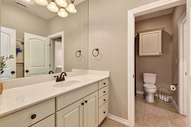 1302 Telluride Dr, Midland, TX 79705 - bathroom featuring vanity, toilet, a chandelier, baseboards, and tile patterned floors