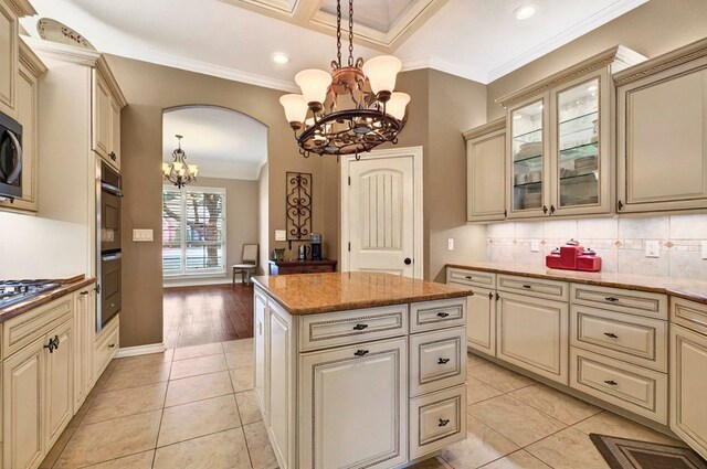1302 Telluride Dr, Midland, TX 79705 - kitchen with a chandelier, cream cabinetry, crown molding, a center island, and backsplash