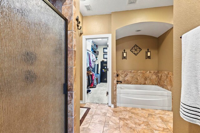 1302 Telluride Dr, Midland, TX 79705 - bathroom featuring a stall shower, a bath, and a spacious closet