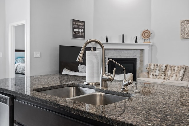 7104 Mcpherson Ln, Midland, TX 79706 - detailed view of a sink, dark stone counters, a brick fireplace, and stainless steel dishwasher