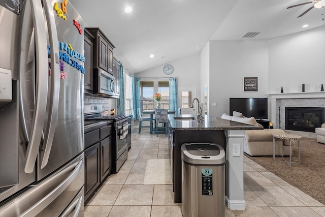 7104 Mcpherson Ln, Midland, TX 79706 - kitchen with appliances with stainless steel finishes, vaulted ceiling, open floor plan, dark stone countertops, and recessed lighting