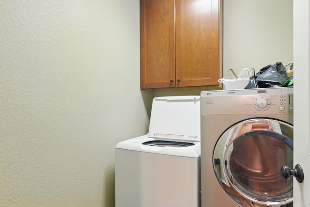 1601 Monterrey Dr, Midland, TX 79703 - laundry room with washer and dryer, cabinet space, and a textured wall