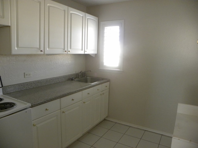 kitchen featuring sink, light tile patterned floors, white cabinets, and white range with electric cooktop