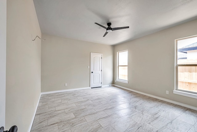 unfurnished room with ceiling fan and a healthy amount of sunlight