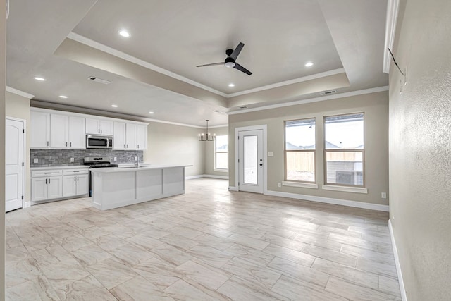 kitchen with appliances with stainless steel finishes, backsplash, a raised ceiling, sink, and white cabinetry