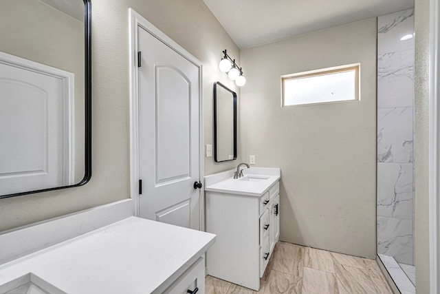 bathroom with vanity and a tile shower