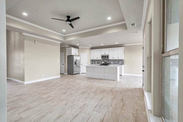 unfurnished living room with a raised ceiling, ceiling fan, and crown molding