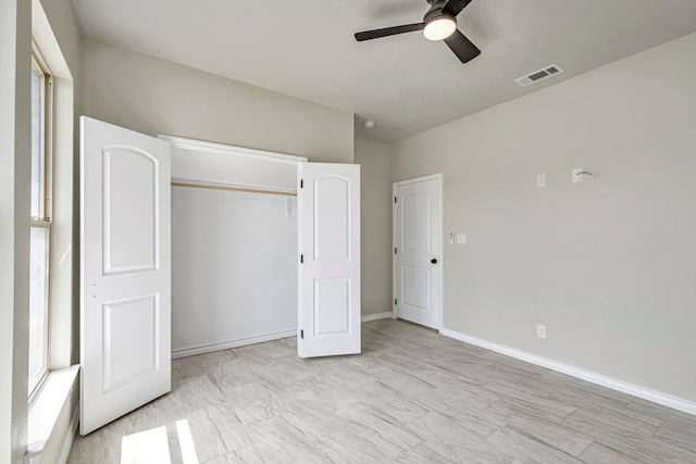 unfurnished bedroom with ceiling fan and a closet