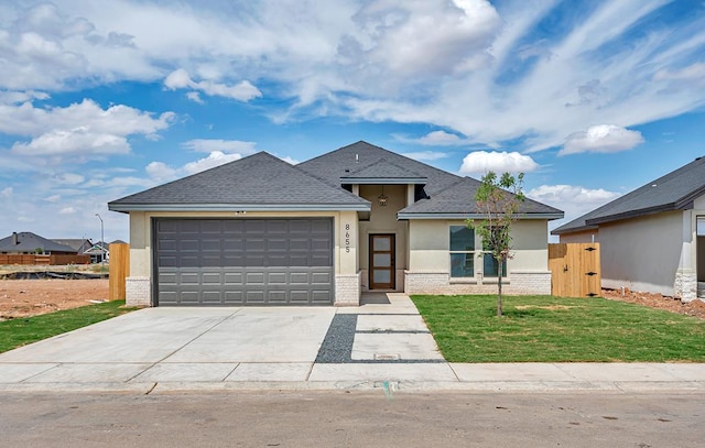 view of front of home with a garage and a front lawn