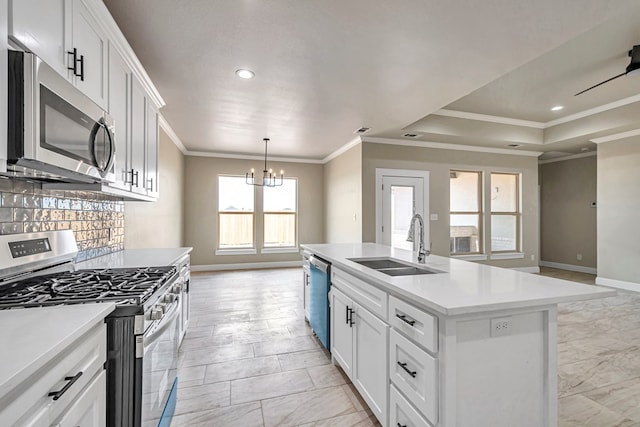 kitchen featuring appliances with stainless steel finishes, a kitchen island with sink, crown molding, sink, and white cabinetry