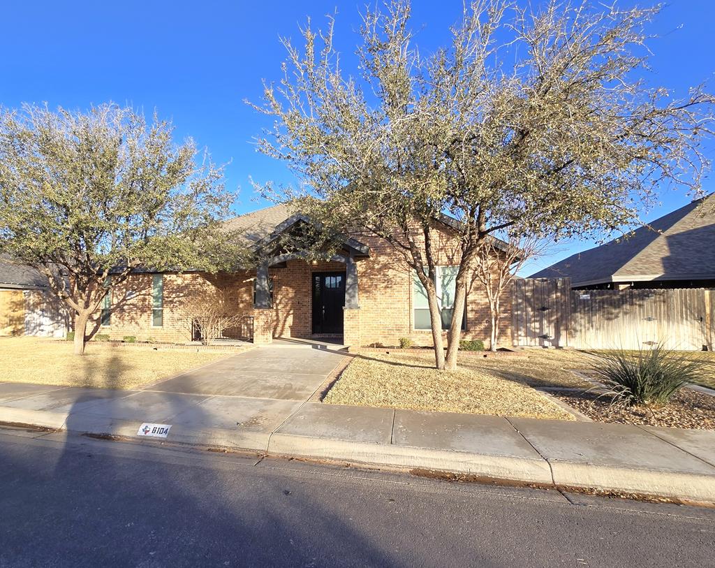 view of front of property featuring fence and brick siding
