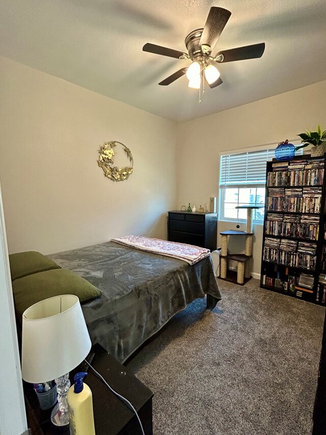 carpeted bedroom with ceiling fan and a textured ceiling