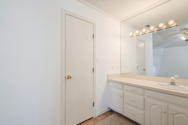 bathroom featuring tile patterned flooring, crown molding, vanity, and a textured ceiling