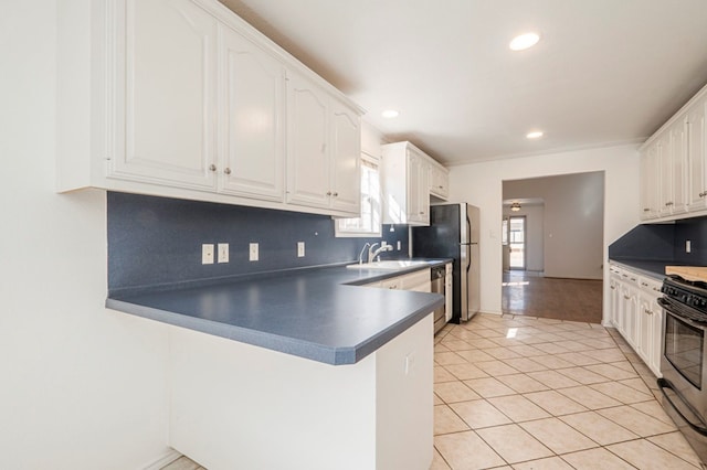 kitchen with stainless steel appliances, dark countertops, white cabinetry, and tasteful backsplash