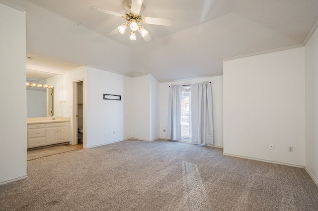 unfurnished bedroom with light carpet, baseboards, ensuite bathroom, and lofted ceiling