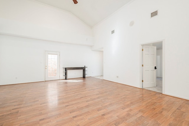 unfurnished living room featuring light wood-type flooring, visible vents, high vaulted ceiling, and a ceiling fan