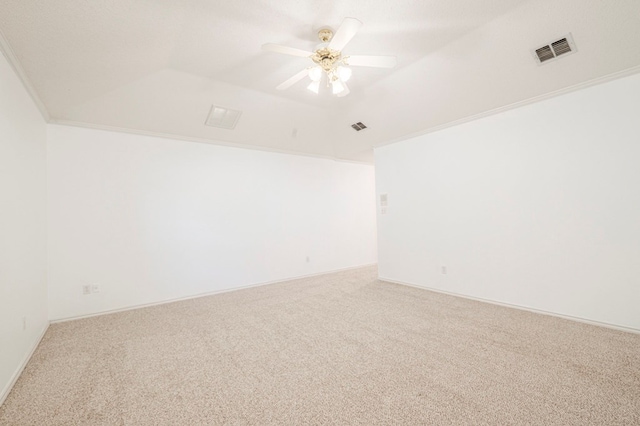 carpeted spare room featuring lofted ceiling, ceiling fan, visible vents, and ornamental molding