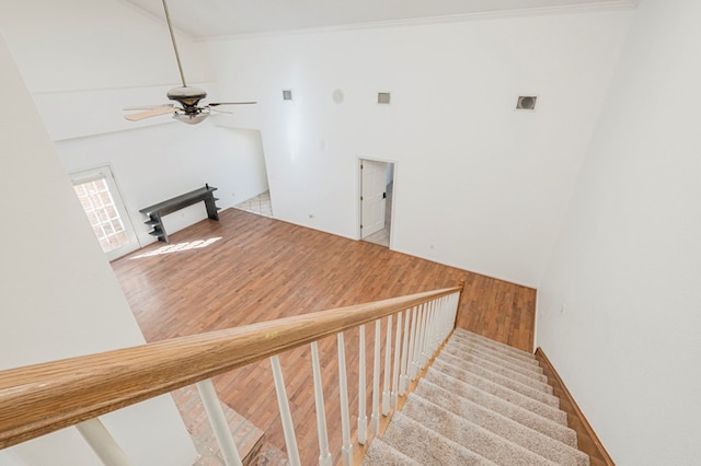 stairway with a ceiling fan, visible vents, and wood finished floors