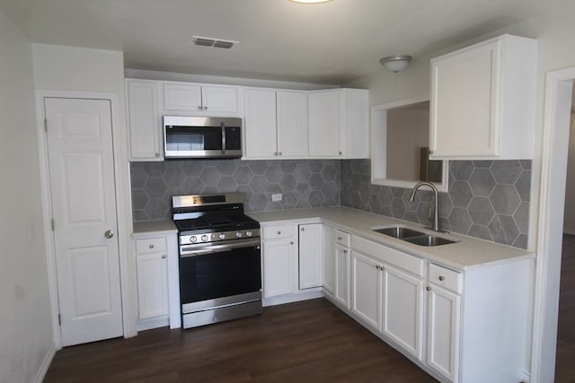 309 W Estes Ave, Midland, TX 79701 - kitchen with stainless steel appliances, dark wood finished floors, light countertops, and white cabinets