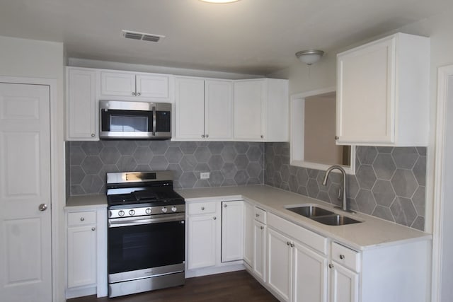 309 W Estes Ave, Midland, TX 79701 - kitchen featuring appliances with stainless steel finishes, light countertops, white cabinetry, and decorative backsplash