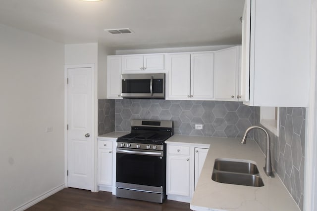 309 W Estes Ave, Midland, TX 79701 - kitchen featuring appliances with stainless steel finishes, dark wood finished floors, white cabinetry, and light stone countertops