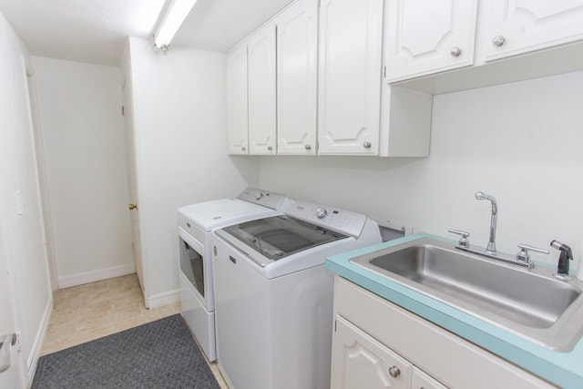 washroom featuring tile patterned flooring, washer and dryer, cabinets, and sink