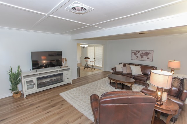 living room featuring hardwood / wood-style floors, coffered ceiling, and an inviting chandelier