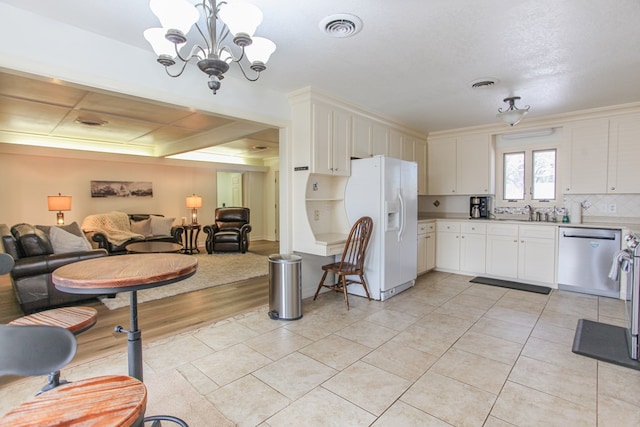 kitchen featuring white cabinetry, dishwasher, white fridge with ice dispenser, a notable chandelier, and decorative light fixtures