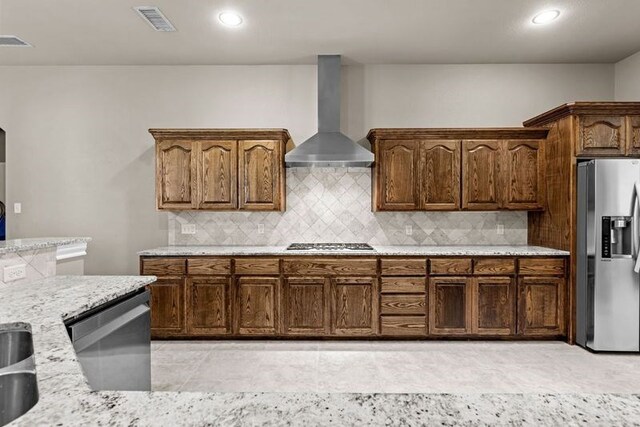 3101 Fairfield Ln, Midland, TX 79705 - kitchen featuring stainless steel appliances, wall chimney range hood, backsplash, light stone counters, and recessed lighting