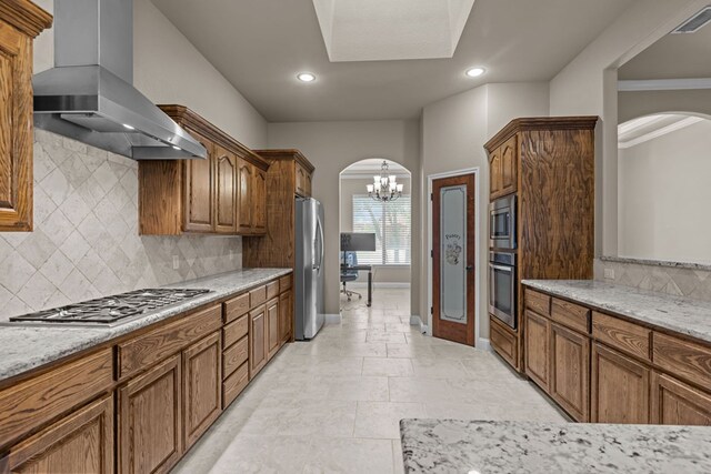 3101 Fairfield Ln, Midland, TX 79705 - kitchen with extractor fan, appliances with stainless steel finishes, arched walkways, a chandelier, and tasteful backsplash
