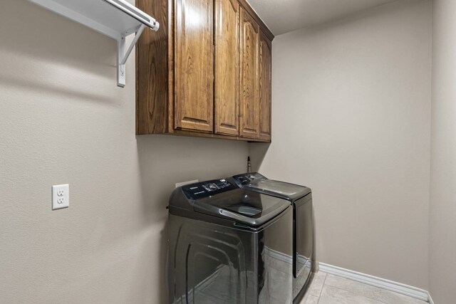 3101 Fairfield Ln, Midland, TX 79705 - laundry room featuring washing machine and clothes dryer, cabinet space, baseboards, and light tile patterned floors
