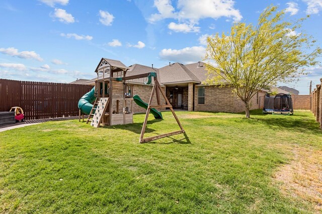 3101 Fairfield Ln, Midland, TX 79705 - back of property featuring a trampoline, brick siding, a playground, and a shingled roof