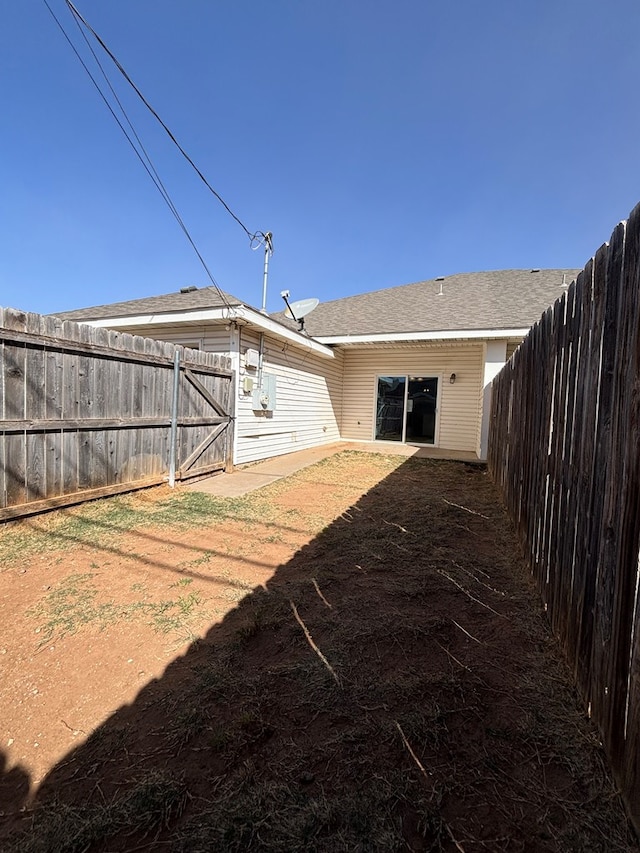 rear view of house with a fenced backyard