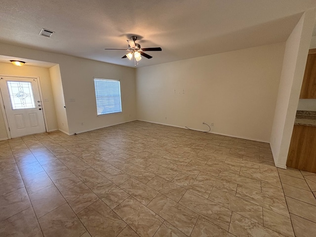 interior space featuring visible vents, baseboards, and ceiling fan