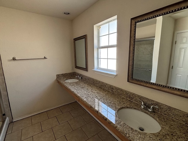 full bathroom with a sink, double vanity, a stall shower, and tile patterned floors