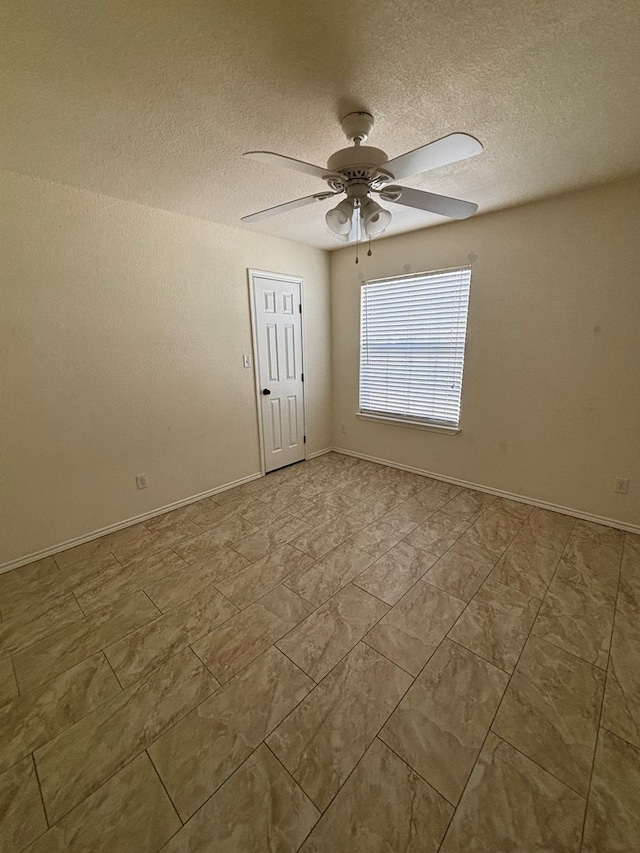 unfurnished room with baseboards, a textured ceiling, and a ceiling fan