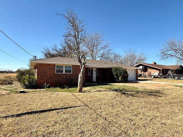 single story home featuring a garage and a front lawn